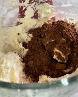 Una ciotola di vetro piena di panna montata e cacao in polvere