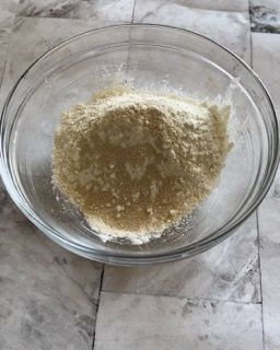 Una ciotola di vetro piena di polvere è appoggiata su un tavolo.