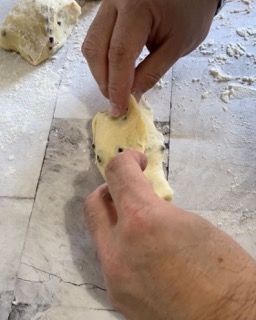 Una persona tiene un pezzo di pasta con le dita.