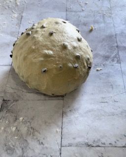 Una grande palla di pasta è appoggiata su un pavimento piastrellato