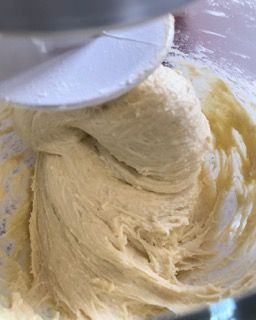 Una persona tiene una spatola sopra una ciotola di pastella.