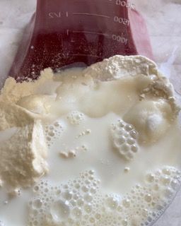 Primo piano di un becher pieno di latte e farina.