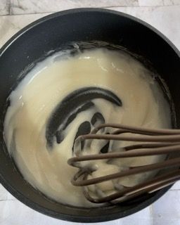 Una ciotola di salsa con dentro una frusta