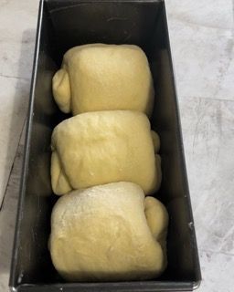 Tre rotoli di pasta sono in uno stampo per plumcake