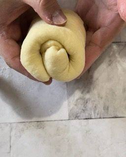 Una persona tiene in mano un rotolo di pasta.