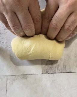 Una persona tiene in mano un pezzo di pasta.