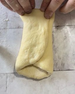 Una persona tiene in mano un pezzo di pasta.