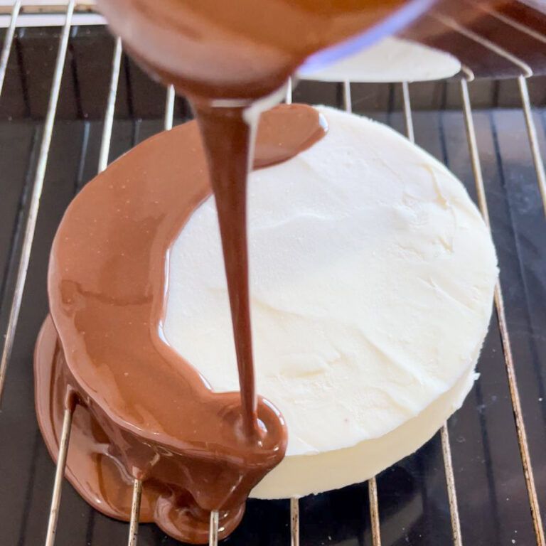 Il cioccolato viene versato su una torta su una griglia di raffreddamento