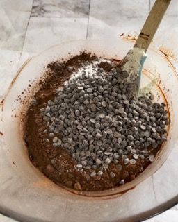 Una ciotola di gocce di cioccolato con una spatola dentro