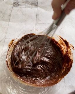 Una persona sta mescolando una ciotola di salsa al cioccolato