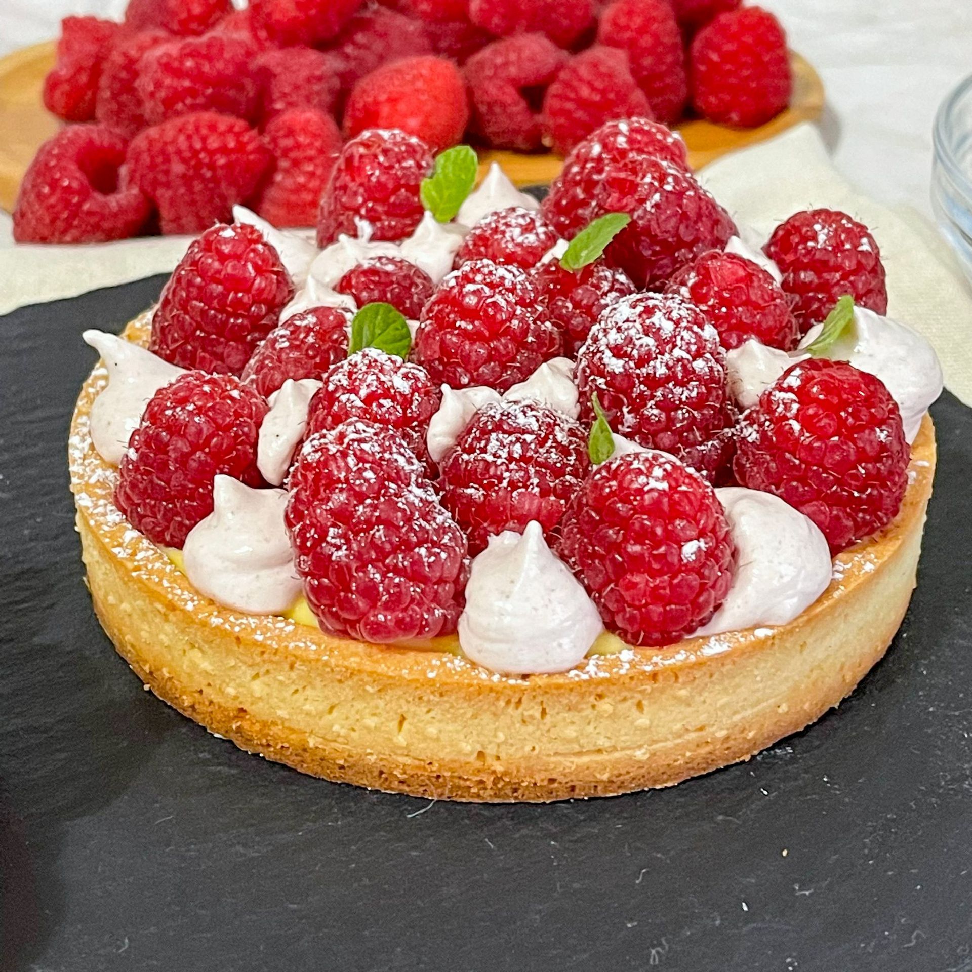 Una torta con lamponi e panna montata sopra