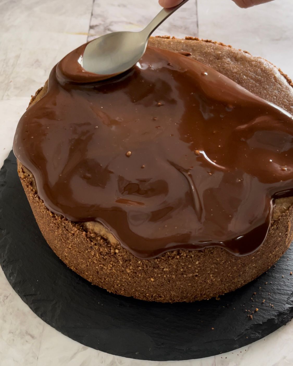Una persona sta spalmando il cioccolato su una torta con un cucchiaio