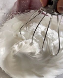 Una persona sta montando la panna in una ciotola.