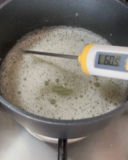 Un termometro viene utilizzato per misurare la temperatura di una pentola piena di liquido.