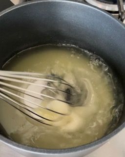 Una pentola di liquido con dentro una frusta