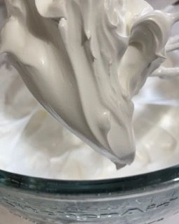 La panna montata viene versata in una ciotola di vetro.