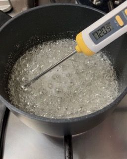 Un termometro digitale viene utilizzato per misurare la temperatura di una pentola piena di liquido.