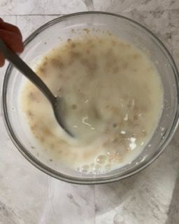 Una persona tiene un cucchiaio in una ciotola di zuppa.