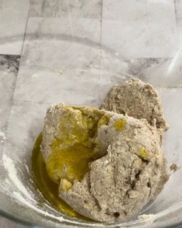 Primo piano di una ciotola di impasto con olio dentro.