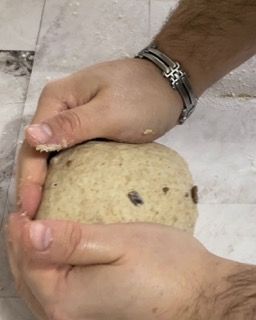 Una persona tiene in mano una palla di pasta.