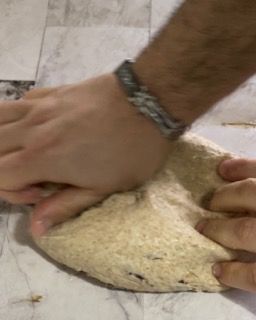 Una persona sta impastando un pezzo di pasta su un tavolo.