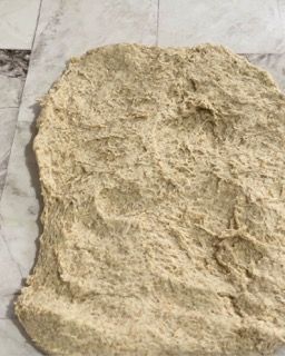 Un pezzo di pasta è appoggiato su una superficie di marmo.
