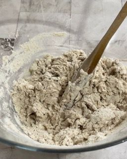 Una ciotola di impasto con un cucchiaio di legno dentro