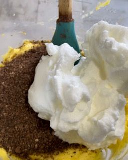 La panna montata viene mescolata in una ciotola con un cucchiaio di legno.