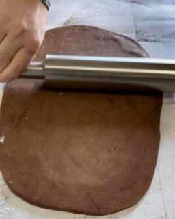 Una persona sta stendendo la pasta con un mattarello