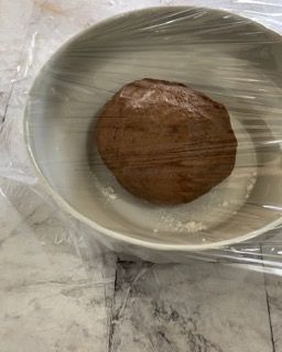 Una ciotola di cibo avvolta nella pellicola trasparente su un tavolo.