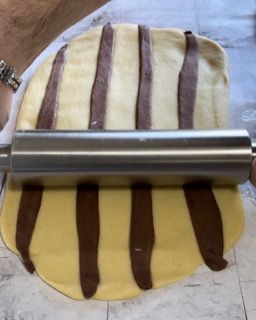 Una persona sta stendendo la pasta con un mattarello