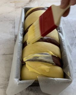Una persona sta spalmando il burro su una pagnotta di pane