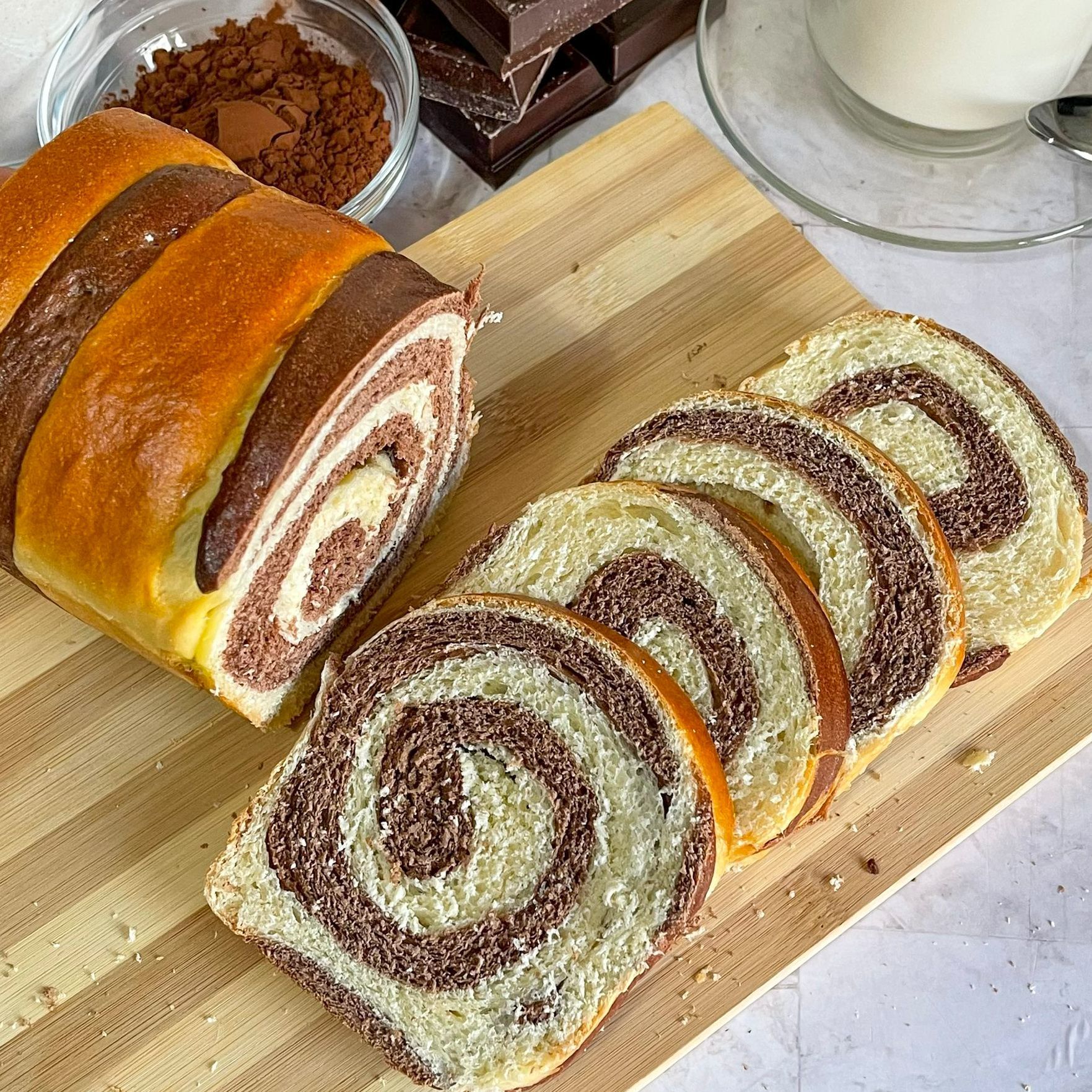 Una pagnotta di pane al cioccolato è appoggiata su un tagliere di legno.