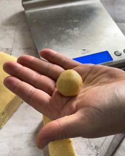 Una persona tiene in mano una pallina davanti a una bilancia.
