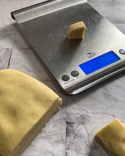 Una bilancia in acciaio inossidabile con sopra due pezzi di impasto.