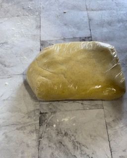 Un sacchetto di polvere gialla è appoggiato su un pavimento piastrellato.