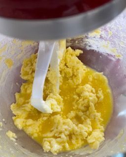 Un mixer mescola le uova e il burro in una ciotola.