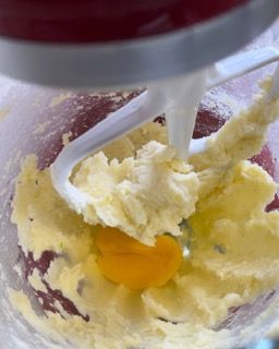 Un uovo viene aggiunto a una pastella in un mixer