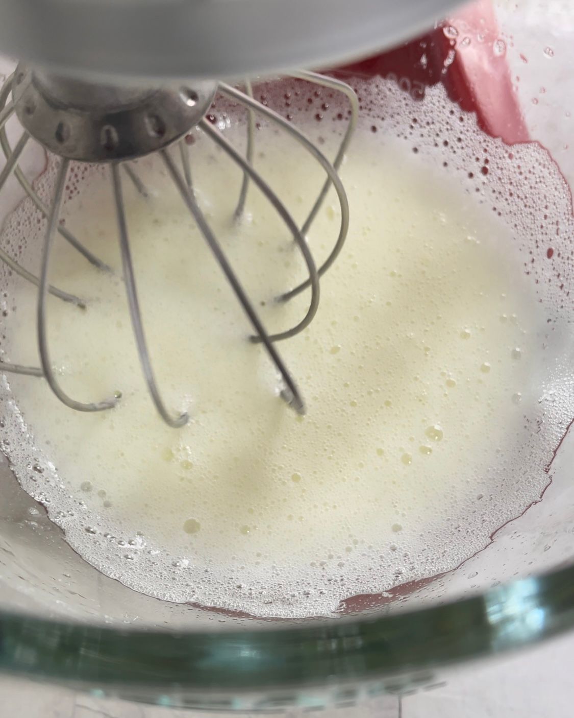 Primo piano di un mixer in una ciotola contenente un liquido schiumoso.