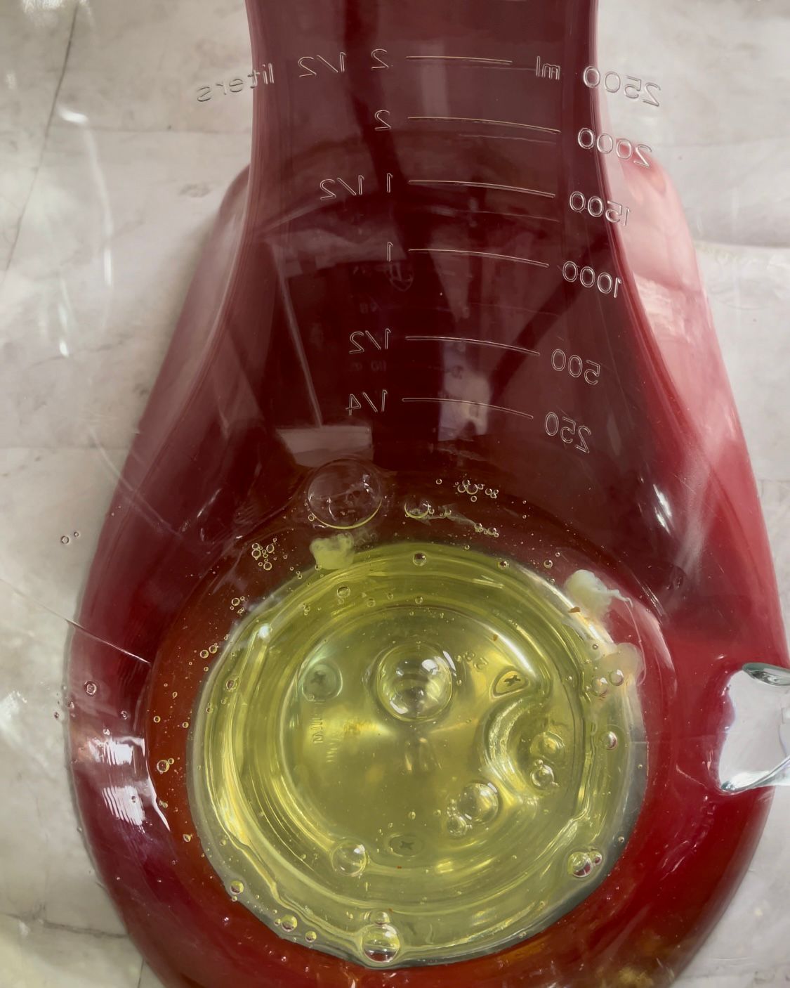 Un misurino rosso con un liquido giallo al suo interno