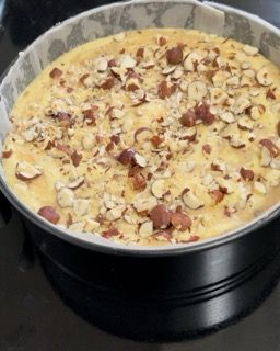 Una pentola di cibo con sopra delle noci su un tavolo.