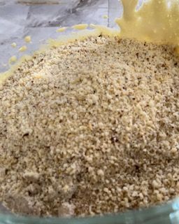 Un primo piano di una ciotola di noci e di una ciotola di pastella.