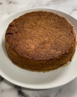 Una torta è appoggiata su un piatto bianco su un tavolo.