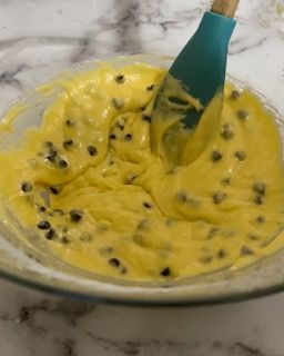 Una ciotola di pastella con gocce di cioccolato e una spatola al suo interno.
