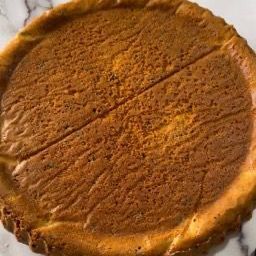 Un primo piano di una cheesecake con le fette staccate su un tavolo.