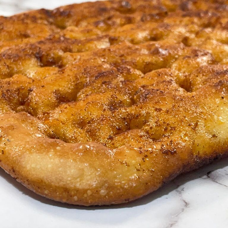 Un primo piano di un pezzo di pane su un piatto su un tavolo.