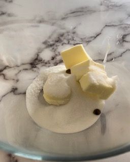 Primo piano di una ciotola di zucchero e burro su un tavolo.