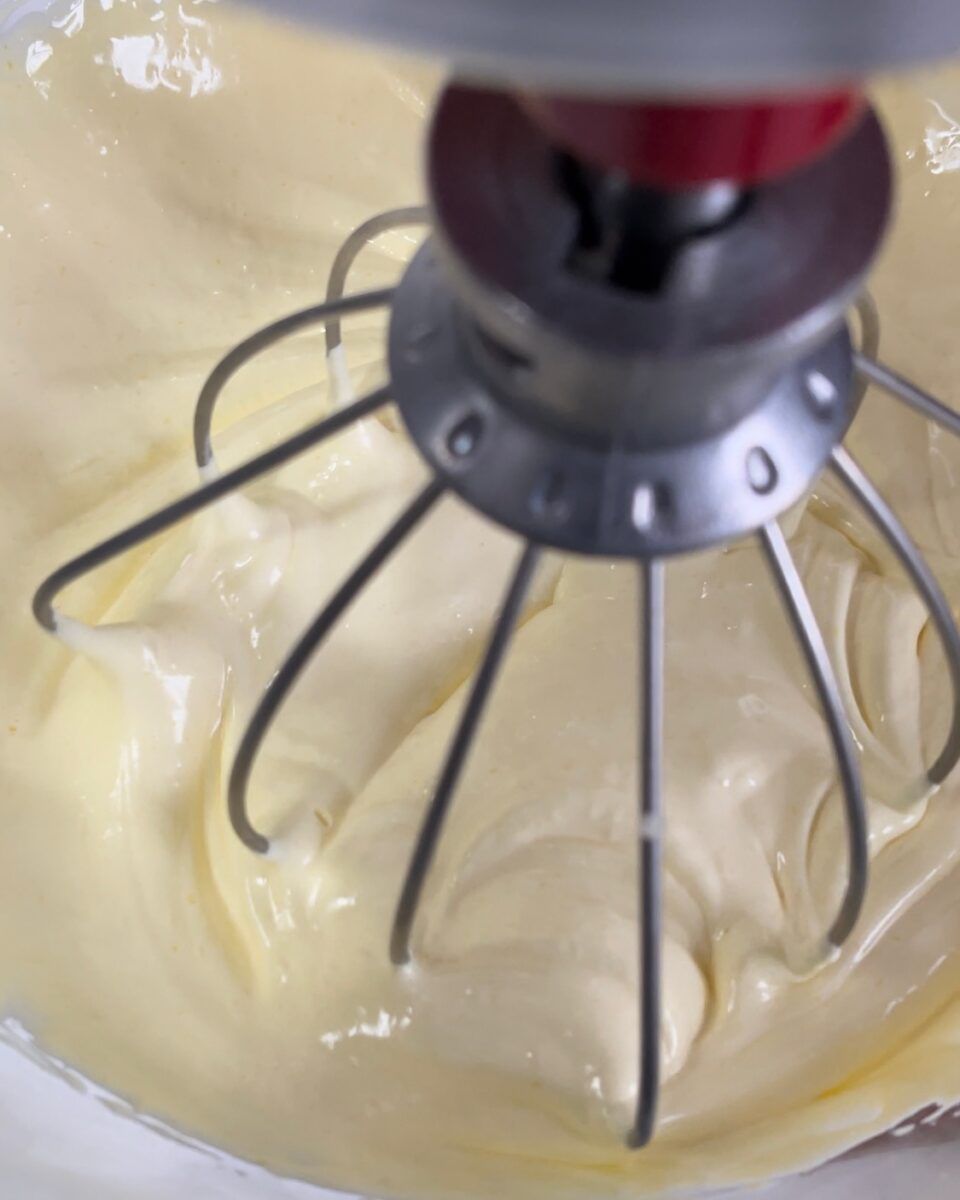 Un primo piano di un mixer con panna montata al suo interno.