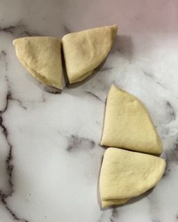 Tre pezzi di pasta sono appoggiati su una superficie di marmo.
