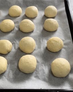 Una teglia di palline di pasta su carta oleata